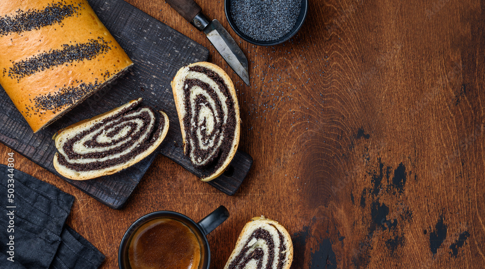 Homemade poppy seed roll cake on a wooden board on the table. Top view. Copy space Homemade poppy seed roll cake on a wooden board on the table. Top view. Copy space