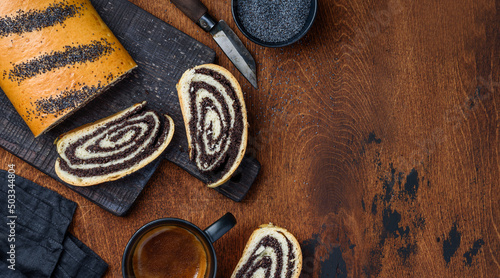 Homemade poppy seed roll cake on a wooden board on the table. Top view. Copy space