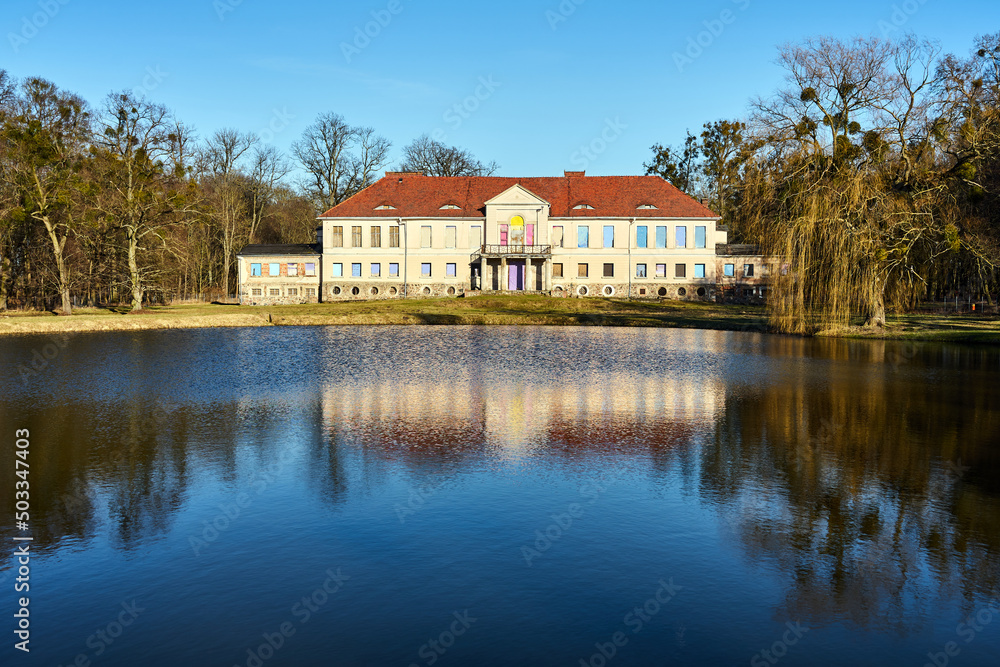 a pond and a ruined, historic palace in the town of Owinska