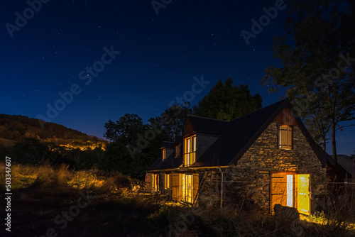 Authentic renovated Pyrenean barn in the Aure valley. exposed stone and wood construction. night shot © mathilde