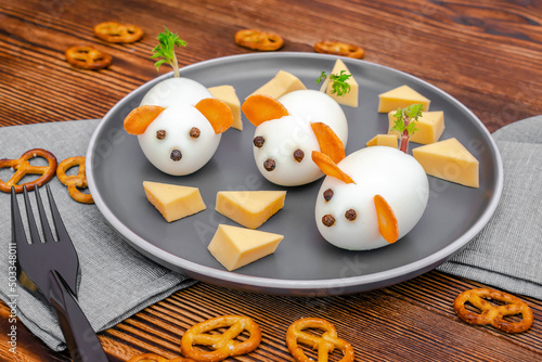 Small chicken eggs mouse,mice with ears of carrot,cheese on plate,creative, fun food,healthy lunch snack idea for kids party. Menu for spooky Halloween dessert treats, edible cute rat selective focus