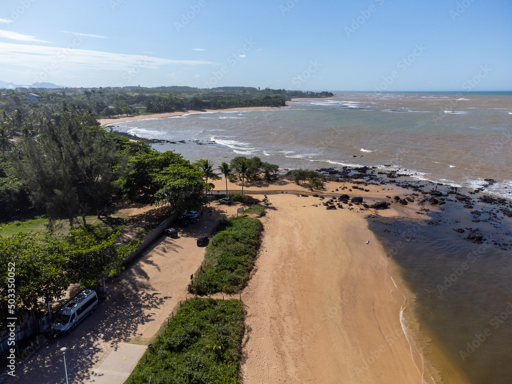 Beautiful beach with dark sands and black rocks like a volcano. Manguinhos, Espirito Santo, Brazil - aerial drone view Beautiful beach with dark sands and black rocks like a volcano. Manguinhos, Espirito Santo, Brazil - aerial drone view
