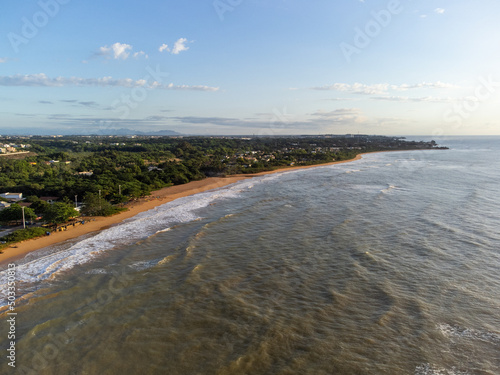 beautiful seaside city of Brazil with dark sand and sunrise on the atlantic ocean - Bicanga  Espirito Santo - aerial drone view