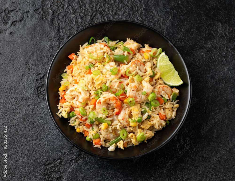 Prawn fried rice with eggs and vegetables in black bowl. Healthy asian food. Prawn fried rice with eggs and vegetables in black bowl. Healthy asian food.