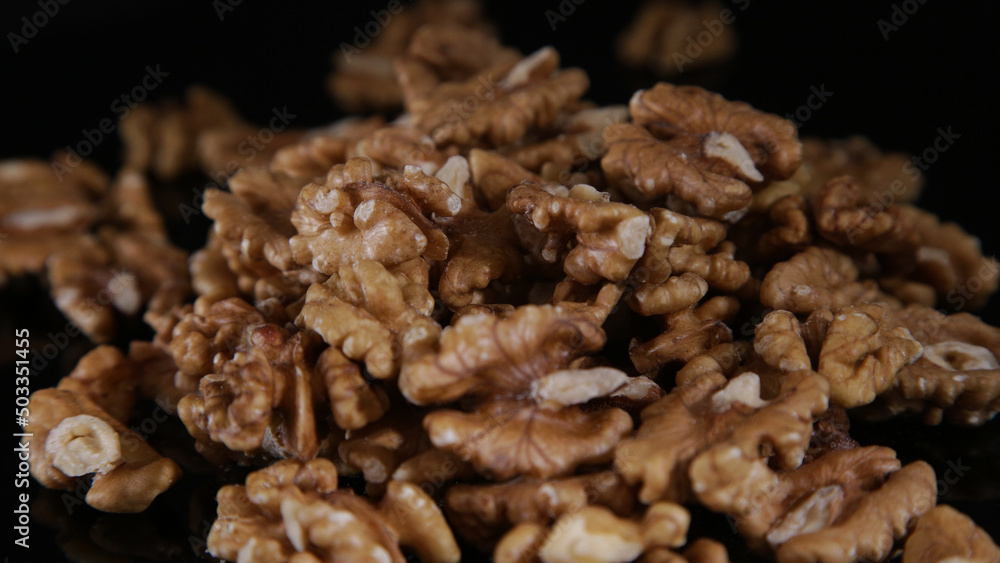 close-up of scattered walnuts on a mirrored black table in the dark close-up of scattered walnuts on a mirrored black table in the dark