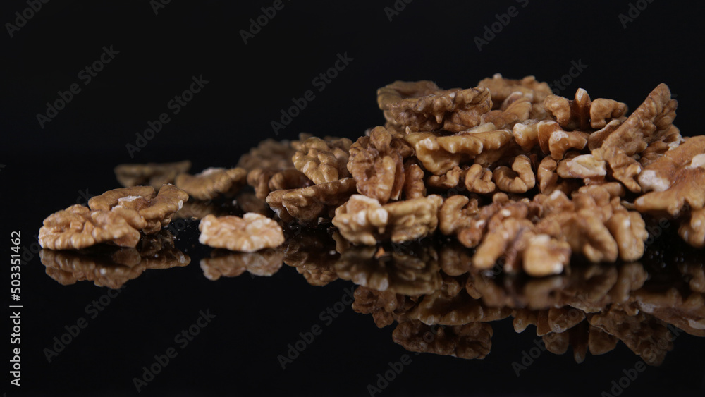 scattered walnuts on black table scattered walnuts on black table