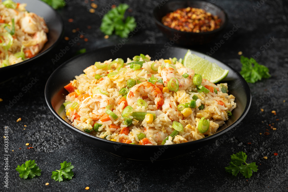 Prawn fried rice with eggs and vegetables in black bowl. Healthy asian food. Prawn fried rice with eggs and vegetables in black bowl. Healthy asian food.