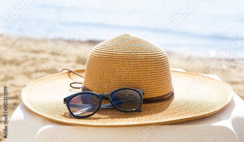 Straw hat and sunglasses on the beach. Beach holiday concept