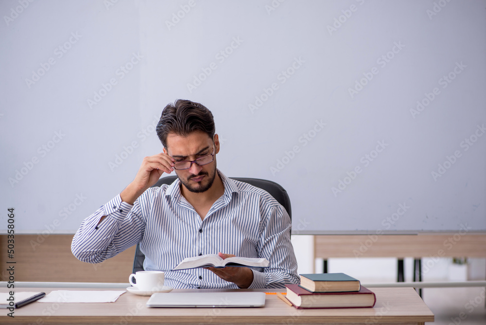 Young male teacher in the classroom Young male teacher in the classroom