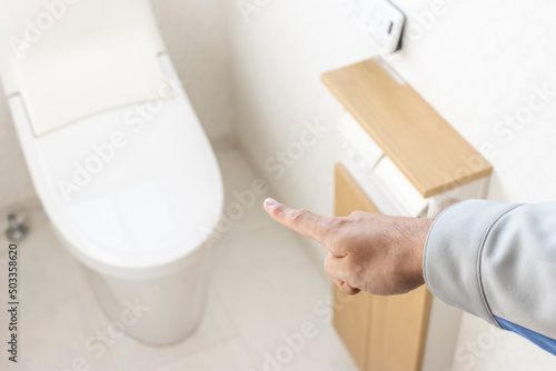 洋式トイレを確認する男の手