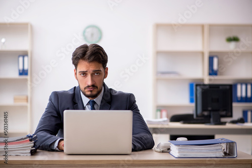 Young male employee working in the office photo