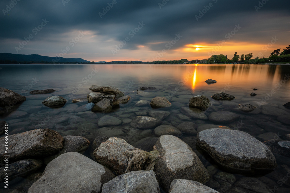 Dramatische Wolken am Seeufer des Bodensee zum Sonnenuntergang 