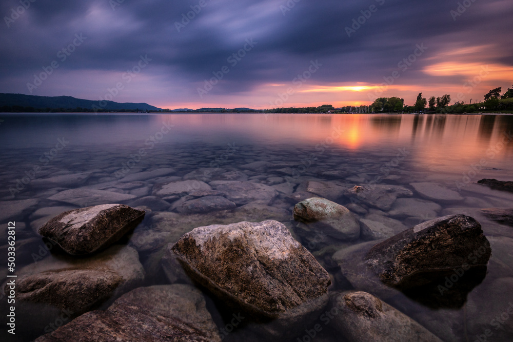 Farbspiel am Bodensee mit schöner Wolkenstimmung und Steinen unter Wasser Farbspiel am Bodensee mit schöner Wolkenstimmung und Steinen unter Wasser