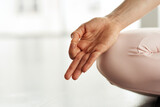 Close-up of unrecognizable woman holding hand in mudra while meditating