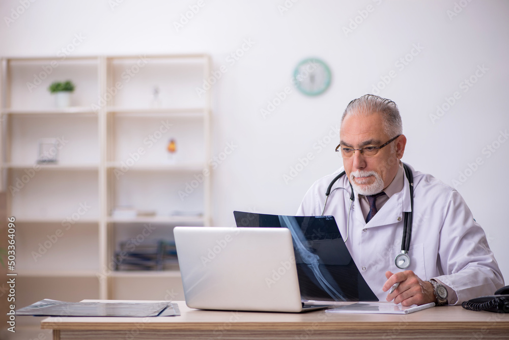 Old male doctor radiologist working at the hospital