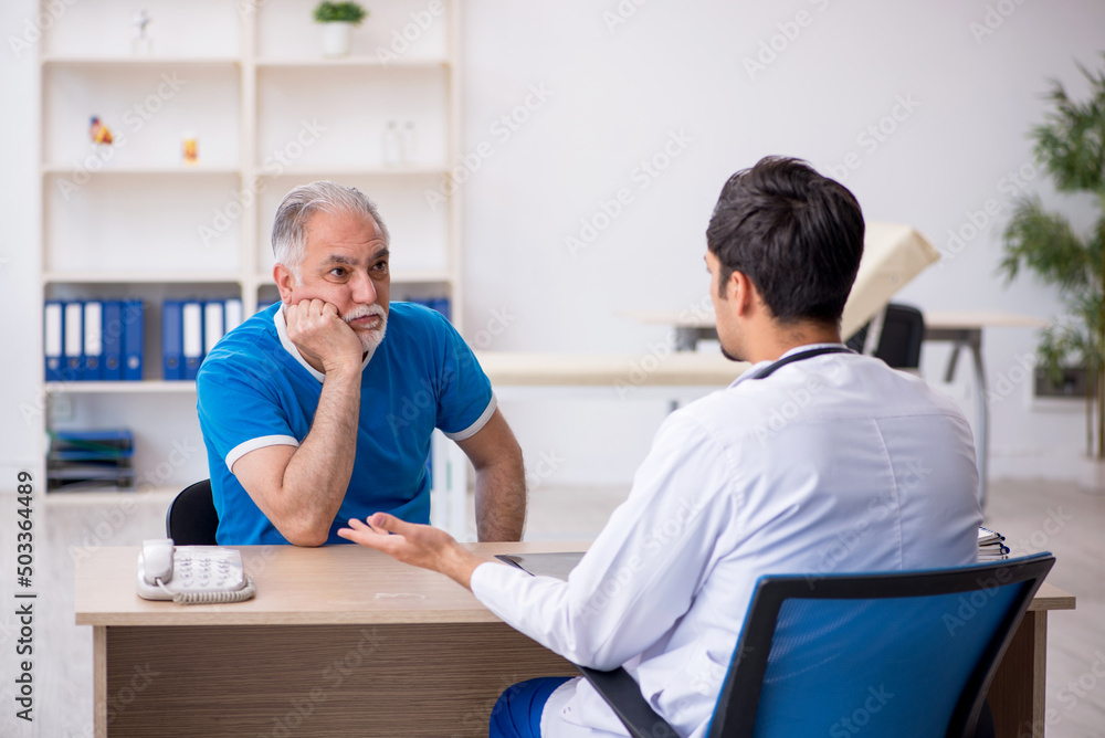 Obraz premium Old male patient visiting young male doctor