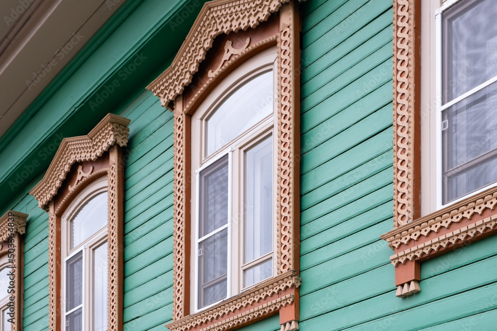 Beautiful old windows. An architectural monument. Old Russian style. Wooden architecture. An old carved frame. Architectural decorative element.