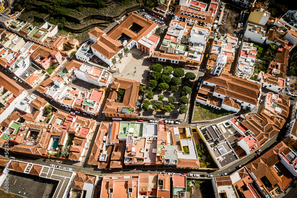 Aerial view of Garachico village on the coast of the Atlantic ocean in Tenerife island of Spain. Town on a rocky shore under the volcano mountain.