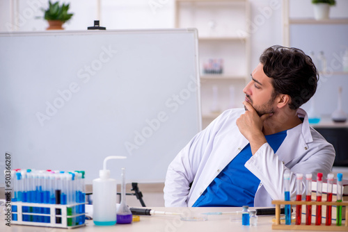 Young male chemist working at the lab