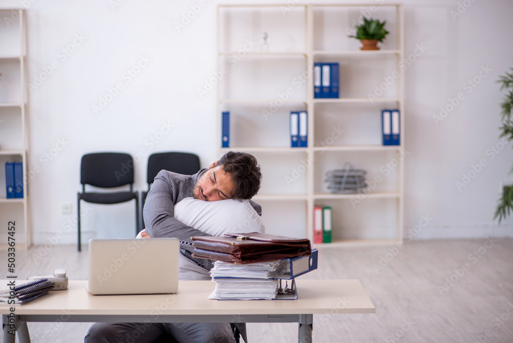 Young male employee in oversleeping concept Young male employee in oversleeping concept