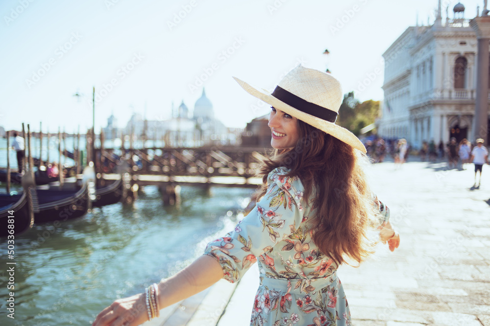 happy elegant woman in floral dress having walking tour