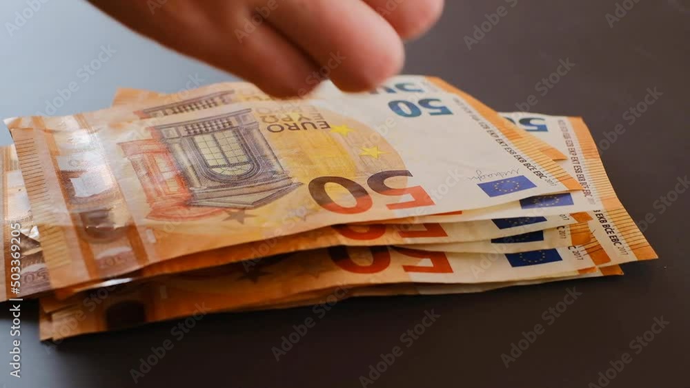 Recalculation of money.fifty euros banknotes pack. hands count euro bills on gray background.fast moving.Euro banknotes in hands close-up.Euro currency. Money in hands. 4k footage Recalculation of money.fifty euros banknotes pack. hands count euro bills on gray background.fast moving.Euro banknotes in hands close-up.Euro currency. Money in hands. 4k footage