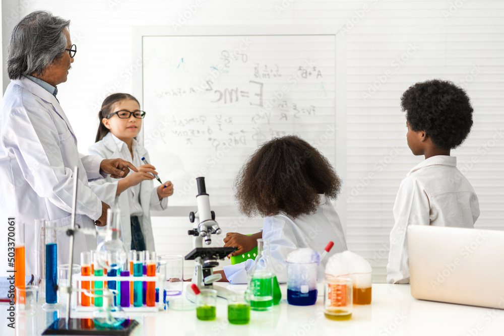 Group of teenage student learn with teacher and study doing a chemical experiment and holding test tube in hand in the experiment laboratory class on table at school.Education concept Group of teenage student learn with teacher and study doing a chemical experiment and holding test tube in hand in the experiment laboratory class on table at school.Education concept