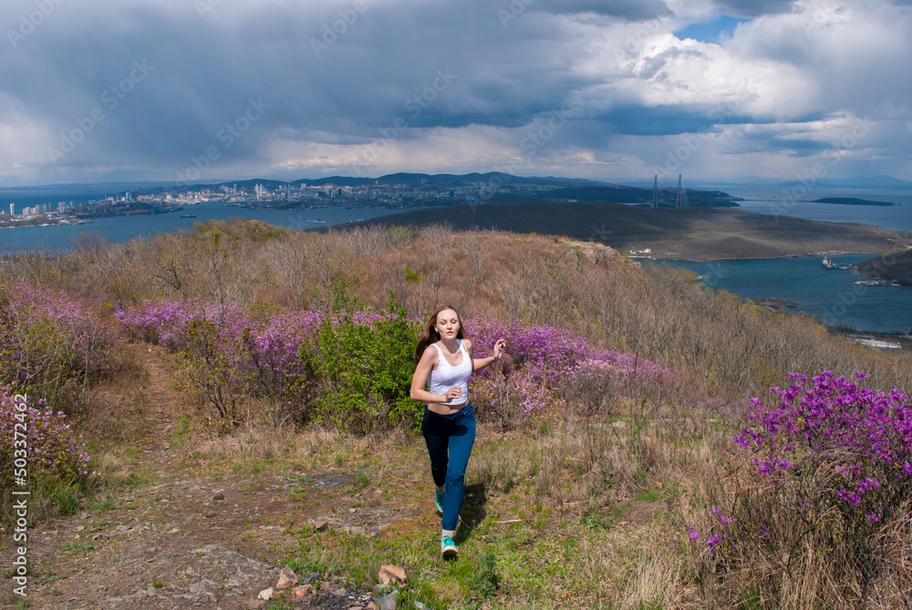 Beautiful girl in a spring meadow with Rhododéndron. 