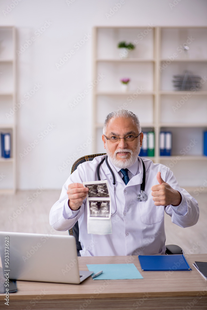 Old male doctor radiologist working in the clinic Old male doctor radiologist working in the clinic