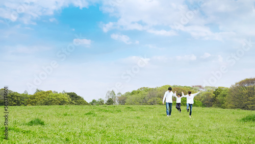 青空の草原を歩く家族　環境　子育て © metamorworks