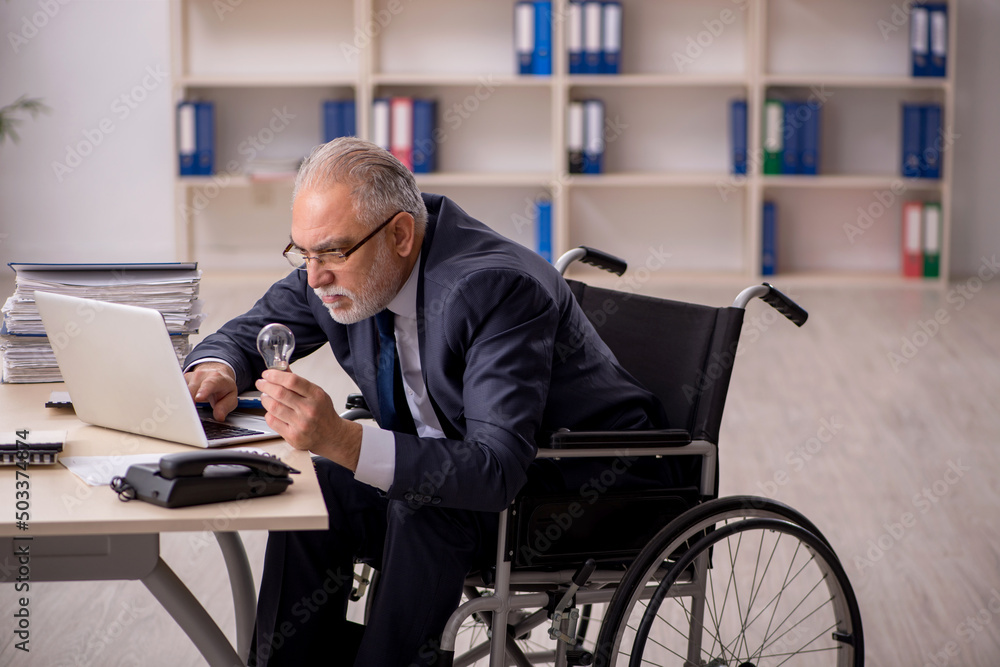 Old male employee in wheel-chair in happy idea concept