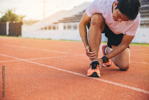 Photography Man runner has twisted ankle injury for practice marathon run at the racetrack