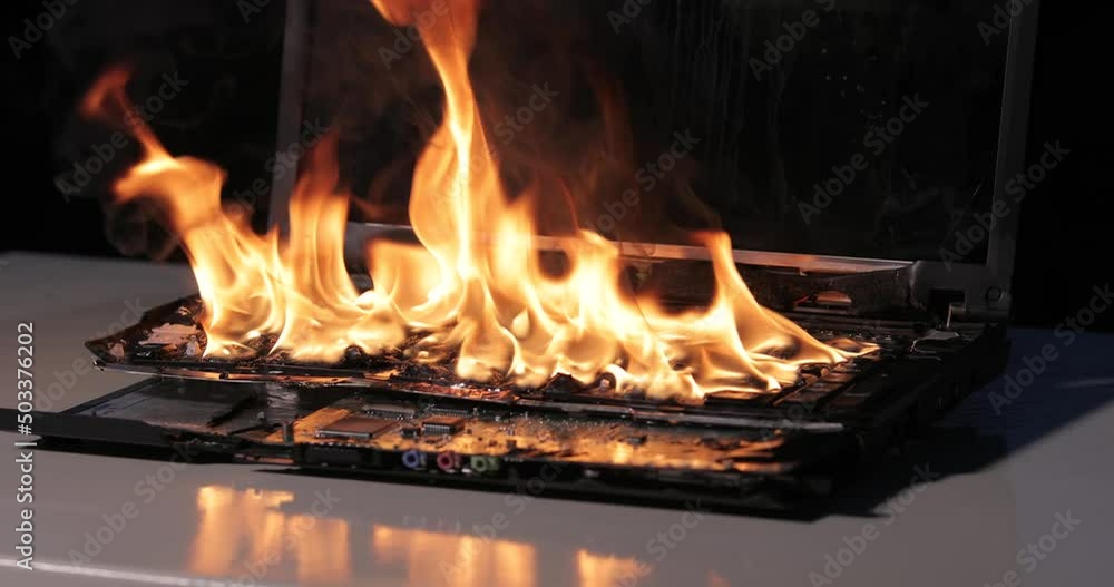 Burning laptop computer electronics closeup Burning laptop computer electronics closeup