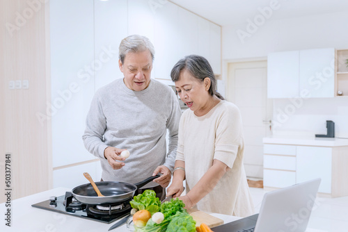 Aged couple making an omelet for breakfast