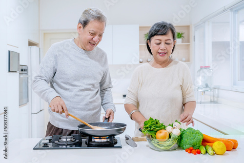 Aged man helping his wife to cooking at home