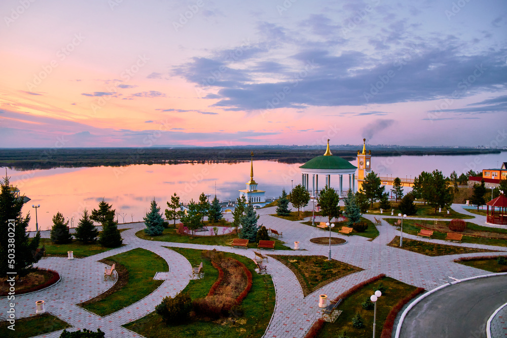 The territory of the tourist complex Zaimka against the background of a bright sunset over the Ussuri River near the city of Khabarovsk. Russia.