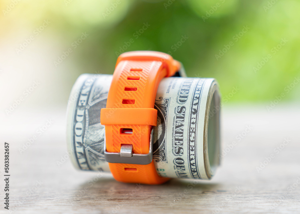 Dollar bill rolled in a watch strap, Stock Photo Adobe Stock