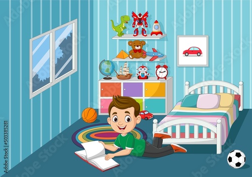 Happy little boy reading a book in bedroom
