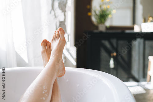 Young happy woman taking bath at home, treat yourself photo