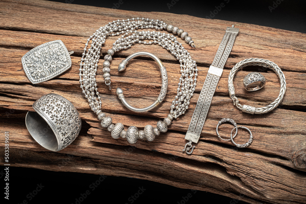 Collection of antique silver jewellery on an old wood log Stock Photo Adobe Stock
