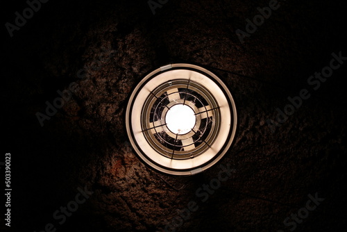 Electric lamp glowing in a dark stone cave