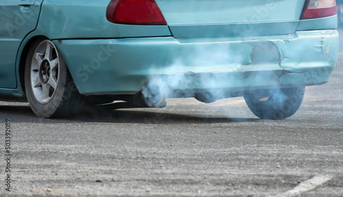 Old car emits pollutant out of the exhaust on street. Air pollution concep.