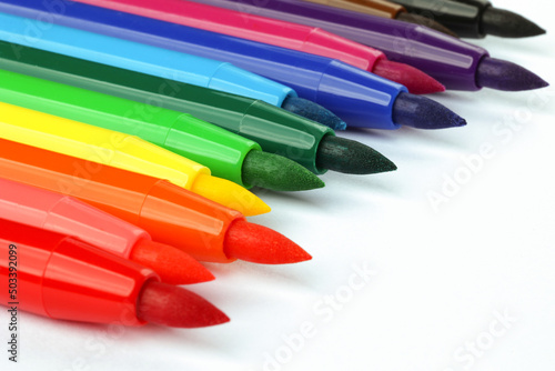 A set of colorful felt-tip pens lying diagonally on white background. Learning concept