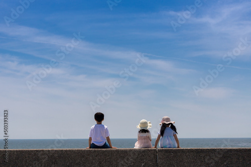 夏の海岸の堤防で遊んでいる子供の姿 Fototapet