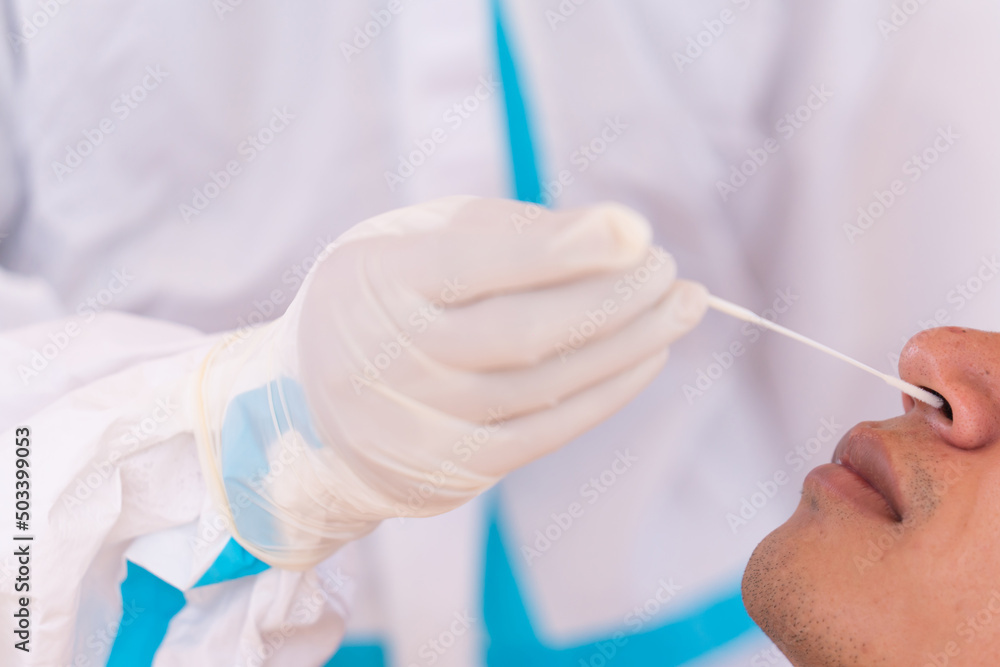 doctor with PPE suit test coronavirus(covid-19) to man by nasal swab by antigen test kit. ATK doctor with PPE suit test coronavirus(covid-19) to man by nasal swab by antigen test kit. ATK