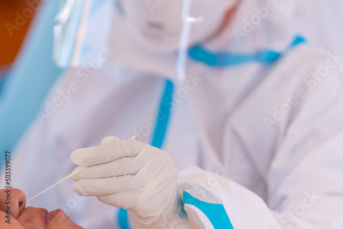 doctor with PPE suit test coronavirus(covid-19) to man by nasal swab by antigen test kit. ATK