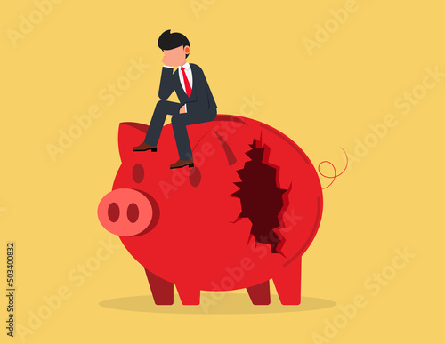 Financial mistake. depressed businessman sitting on a broken piggy bank, poverty or bankruptcy concept