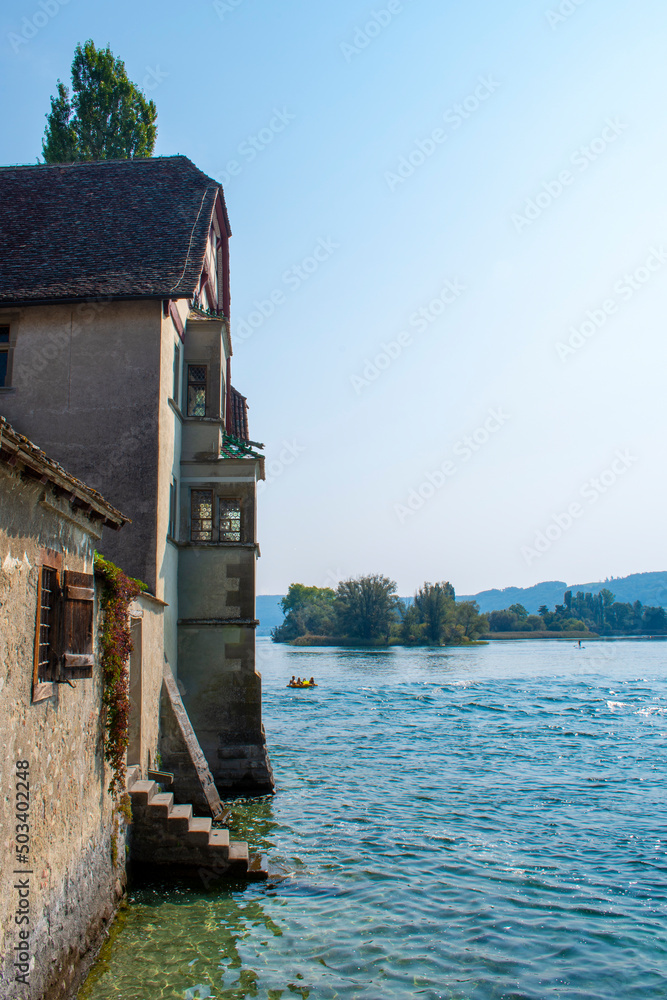 The view of St. George's Abbey (Kloster Sankt Georgen) vintage weathered facade walls headed on the Rhine river on warm sunny day in summer in Swiss town