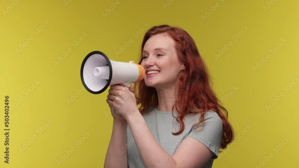 Excited young Caucasian woman 20s posing isolated on yellow background studio. People sincere emotions lifestyle concept. Curly ginger girl Looking aside screaming in megaphone. Excited young Caucasian woman 20s posing isolated on yellow background studio. People sincere emotions lifestyle concept. Curly ginger girl Looking aside screaming in megaphone.