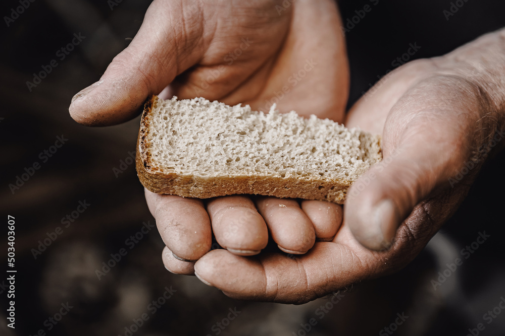 Dirty hands homeless old poor man with piece of bread, top view. Concept global crisis, economic recession Dirty hands homeless old poor man with piece of bread, top view. Concept global crisis, economic recession